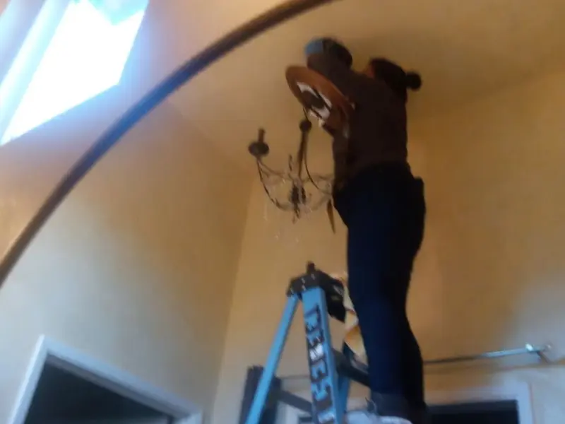 Electrician installing a chandelier in a Snohomish residence